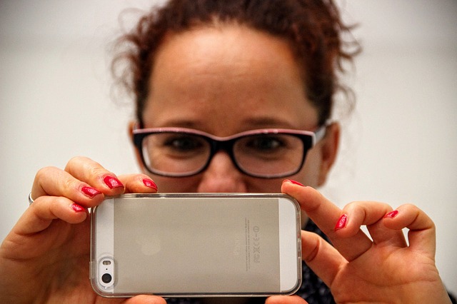 žena fotící iPhonem